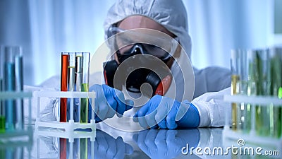 Male chemist checking test tubes with biohazard substance, toxicology testing Stock Photo