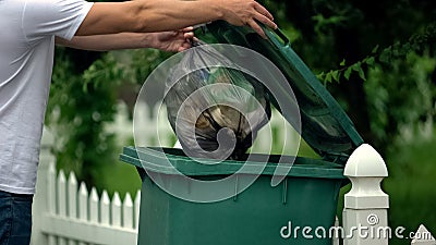 Male citizen throwing garbage in trash can, preventing littering, environment Stock Photo