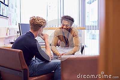 Male College Student Meeting With Campus Counselor Discussing Mental Health Issues Stock Photo