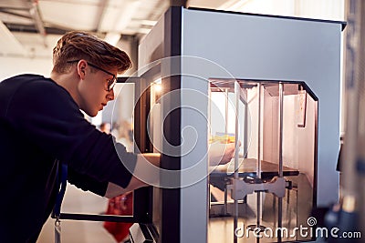 Male College Student Studying Engineering Using 3D Printing Machine Stock Photo