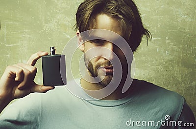 Male cologne. guy with black perfume bottle Stock Photo