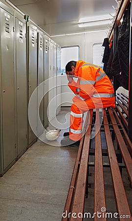 A male construction or railway worker being isolated at work because of mental health or well-being problems Stock Photo