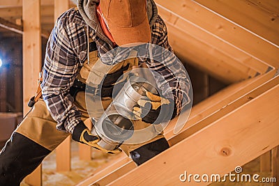 Male Contractor Assembling HVAC Pipes In Attic Of New House Stock Photo