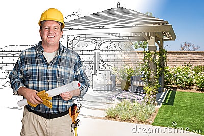 Male Contractor With House Plans Wearing Hard Hat In Front of Structure Stock Photo