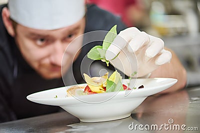 Male cook decorating dish Stock Photo