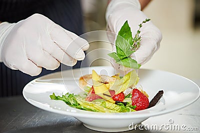 Male cook decorating dish Stock Photo