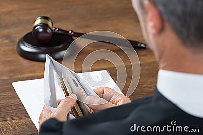 Judge Counting Money In Envelop At Table Stock Photo