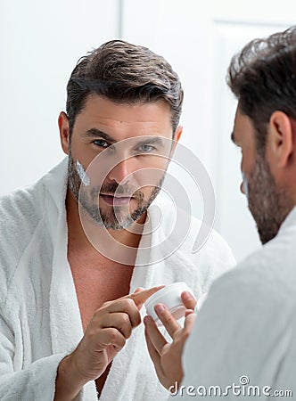 Male cosmetic. Beauty man applying face cream. Skin care cosmetic. Male cosmetics face cream. Facial cream, moisturizing Stock Photo