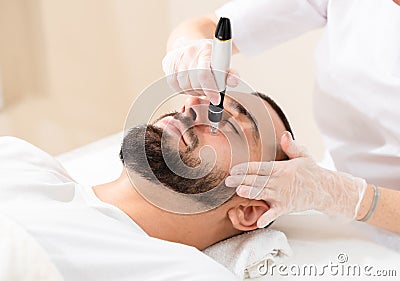 Male cosmetology. Dermastamp fractional mesotherapy treatment for man Stock Photo