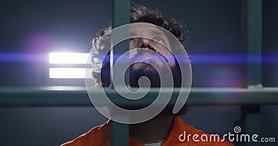 Male criminal holds metal bars with handcuffed hands Stock Photo