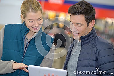 Male customer showing digital tablet to female vendor Stock Photo