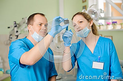 Male dentist showing x-ray to female assistant at dental clinic Stock Photo