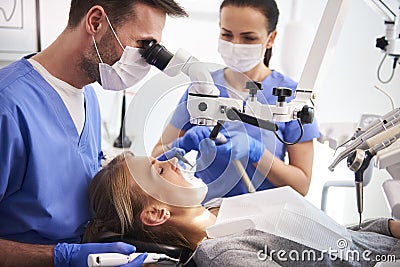 Male dentist working with dental microscope Stock Photo