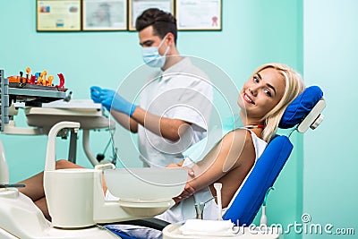 Male dentist. Young blonde girl sitting at the dentist and lookiing at the camera. Stock Photo