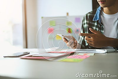 Male designer working on app development, using smartphone and sketches to refine user interface Stock Photo