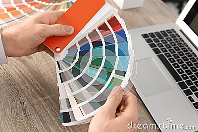 Male designer working with color palette at office table Editorial Stock Photo