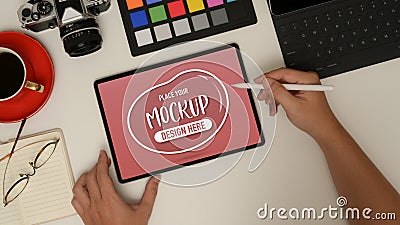 Male designer working with mock up tablet, colour checker, camera and supplies Stock Photo