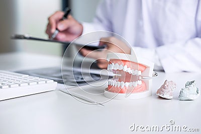 Male doctor or dentist writing report working with tooth x-ray f Stock Photo