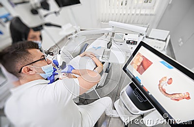 Male doctor examining patient teeth with intraoral scanner. Stock Photo