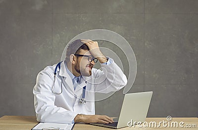 Male doctor forgot something and slapping forehead with palm and closing eyes. Stock Photo