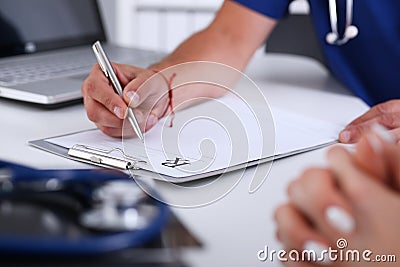 Male doctor hand write prescription at office worktable Stock Photo