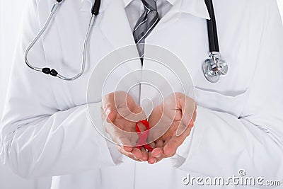 Male Doctor Holding Aids Ribbon Stock Photo