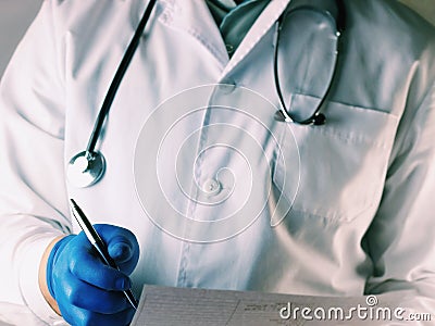 Male Doctor holding application form while consulting patient. Doctor in a white mask. Doctor holds a pen in his hand Stock Photo