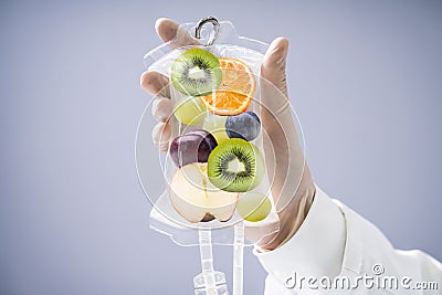 Doctor Holding Saline Bag With Fruit Slices Inside In Hospital Stock Photo