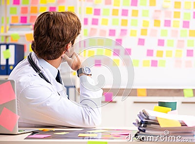 Male doctor with many conflicting prioritites Stock Photo