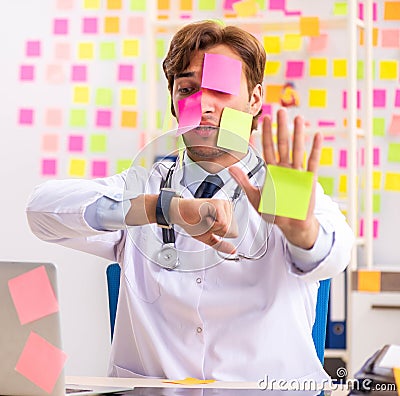 Male doctor with many conflicting prioritites Stock Photo