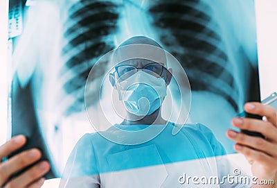 Male doctor portrait throught the patient chest x-ray film lungs scan at radiology department in hospital.Covid-19 scan body xray Stock Photo