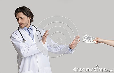 Male doctor refusing to take bribery money from patient Stock Photo