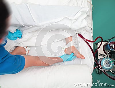 Male doctor touches the patient`s feet to assess the blood motio Stock Photo