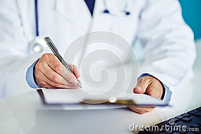 Male doctor writes notes on the clipboard Stock Photo