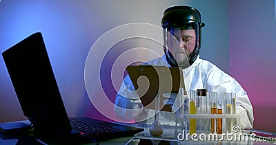 Male doctor is writing research in laboratory with danger virus and infection in vials Stock Photo