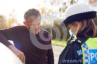 Male Driver Being Stopped By Female Traffic Police Officer For Driving Offence Stock Photo