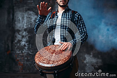 Male drummer playing on wooden drum Stock Photo