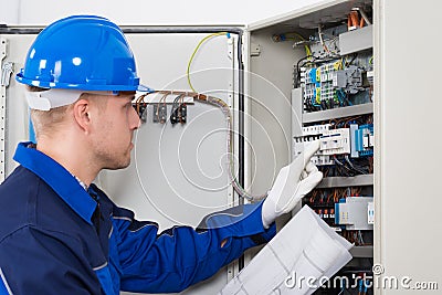 Male Electrician Testing Fusebox Stock Photo