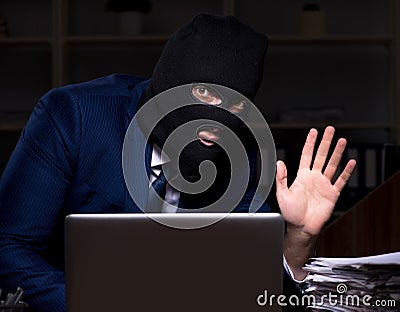 Male employee stealing information in the office night time Stock Photo