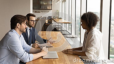 Male employers talk with female candidate at meeting Stock Photo