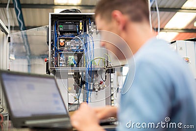 Male Engineer In Factory Using Laptop Computer Stock Photo