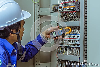 Male engineers are checking the electrical system with electronic tools, clamp-on, clip amp ,clamp meter Stock Photo