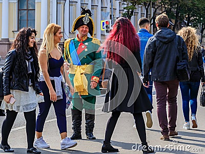 Male entertainer in period outfit approaching tourists for photo opportunities near Palace Square in Saint Petersburg, Russia Editorial Stock Photo