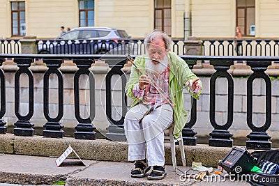 Male entertainer in period outfit awaiting tourists for photo opportunities near Palace Square in Saint Petersburg, Russia Editorial Stock Photo