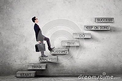Male entrepreneur on stairs with strategy plan Stock Photo
