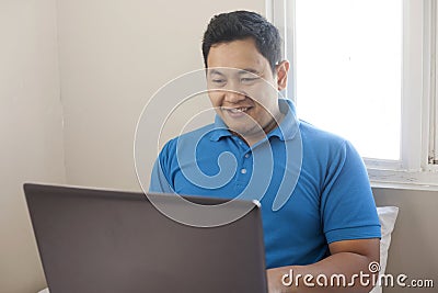 Male Entrepreneur Working Online Business From Home, Happy Smiling Expression Looking at Laptop Stock Photo