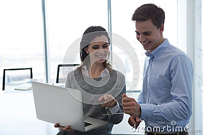 Male executive and female executive working over glass digital tablet Stock Photo