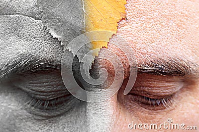 Male eyes are looking down at the forehead sheet. half of the image is colored silver. the arrival of oldness is not avoided Stock Photo