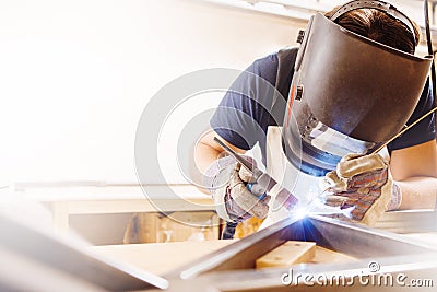 Male in face mask welds with argon-arc welding Stock Photo