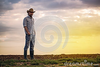 Male Farmer Standing on Fertile Agricultural Farm Land Soil Stock Photo